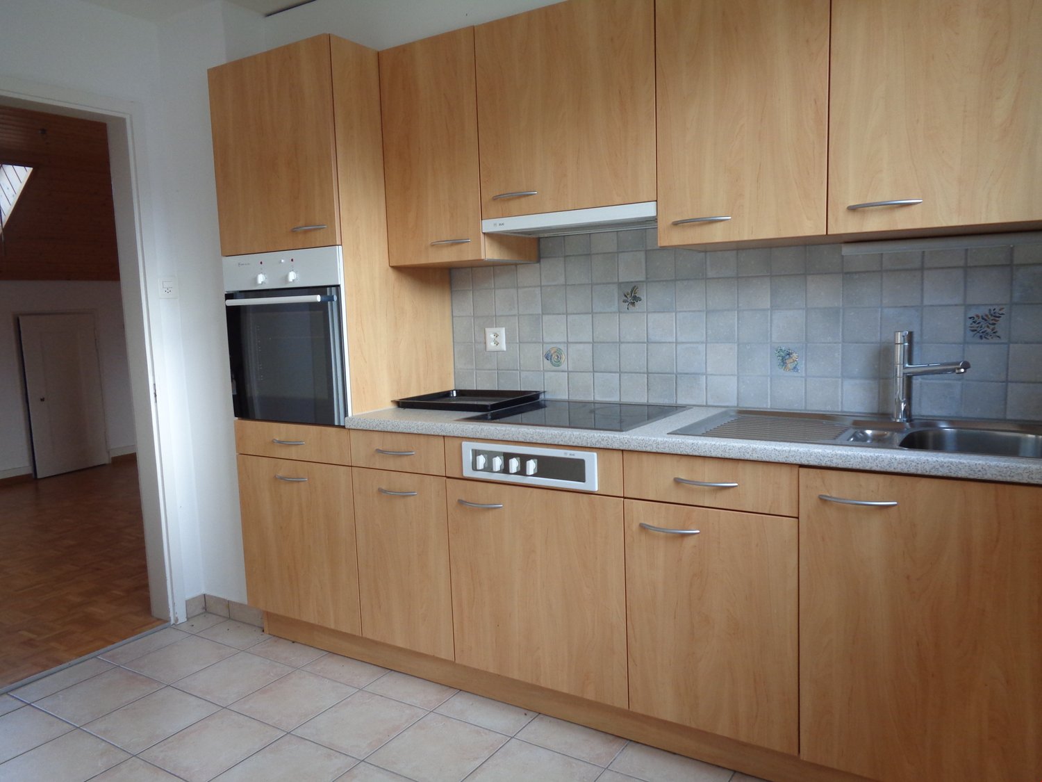 Spacious kitchen with wooden cabinets, tiled backsplash, built-in oven, and dishwasher