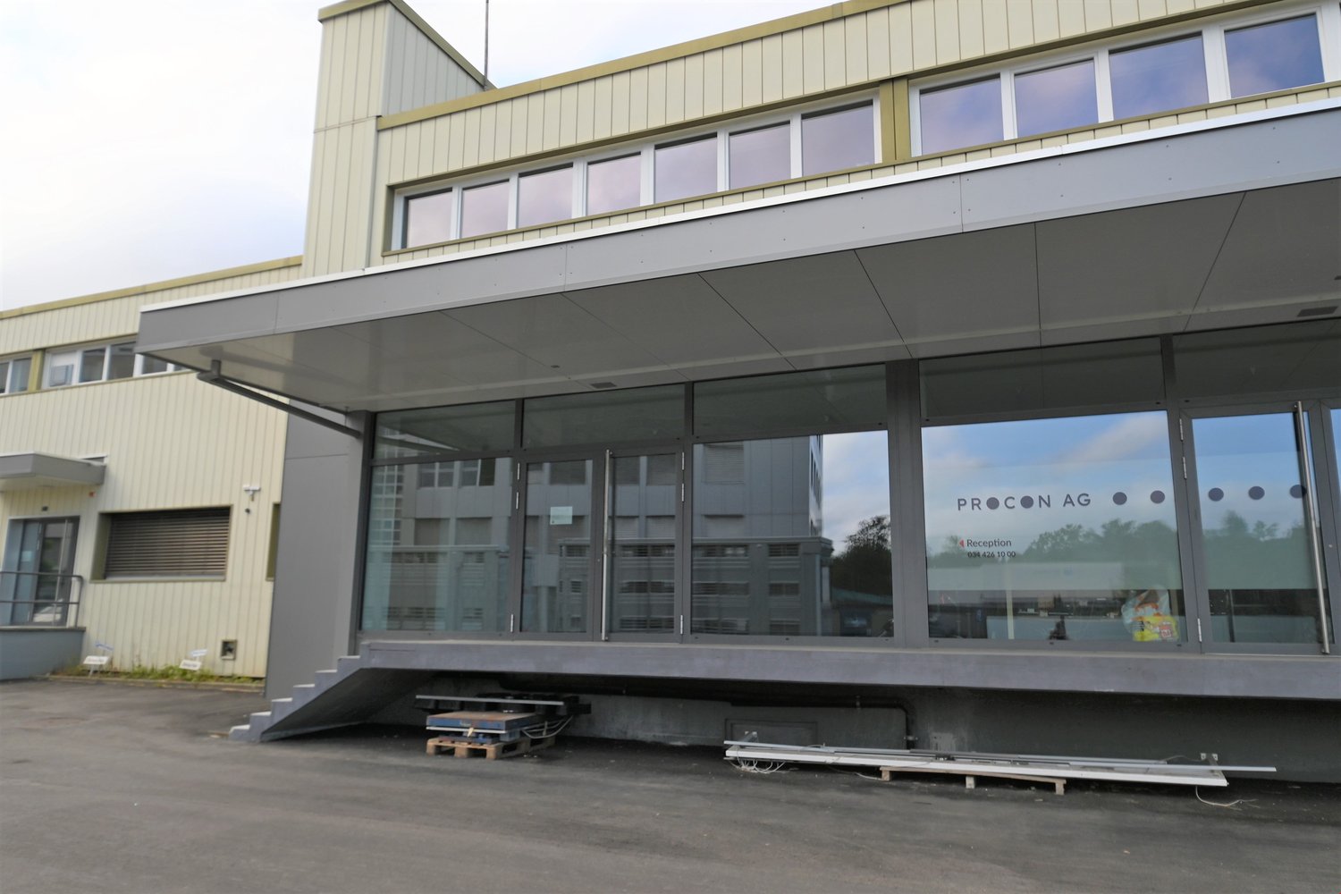 modern building, large glass windows, entrance with stairs, reception area