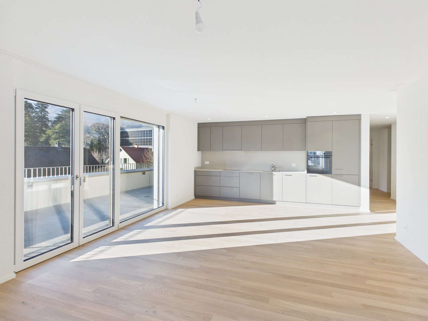 wooden floor, large windows, balcony, sliding glass doors, modern kitchen, white walls
