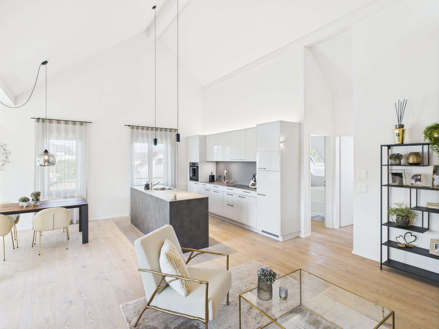 modern kitchen with island, dining table, living room with armchair, coffee table, shelves, wooden floor
