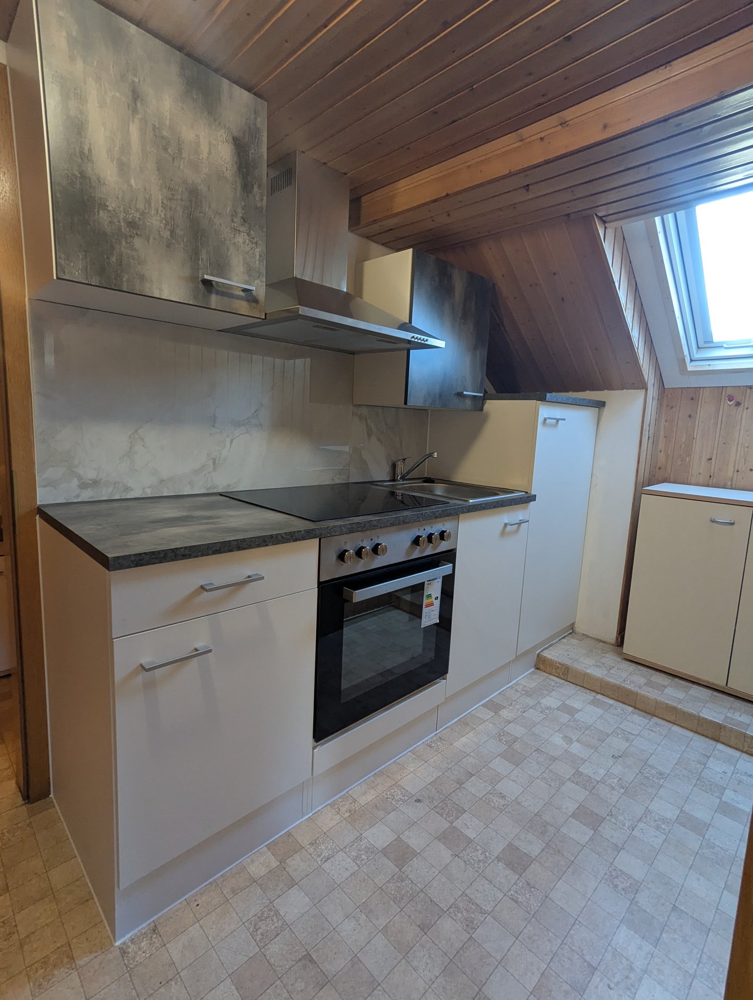 kitchen with white cabinets, tiled floor, granite countertop, gas stove, oven, sink, faucet, wooden ceiling