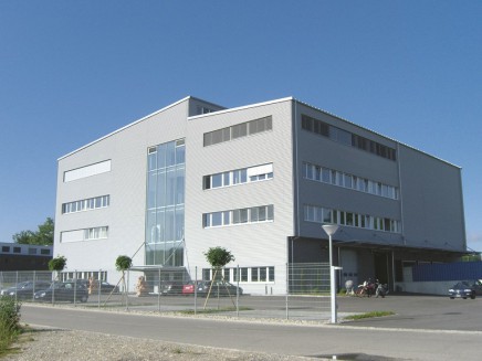 modern office building, white exterior, glass windows, multiple floors, parking lot, cars parked