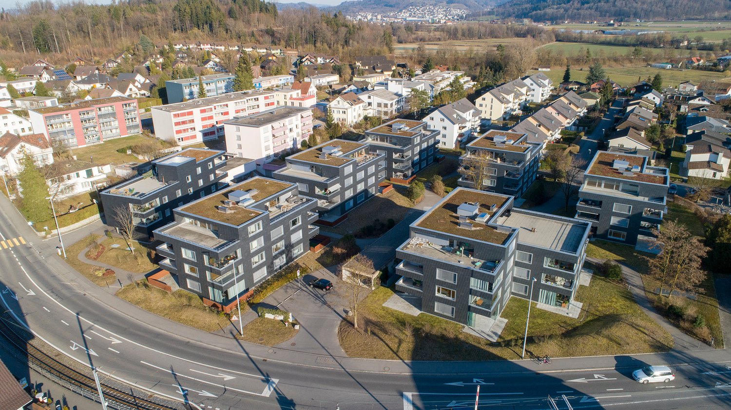 Residential apartment buildings with green roofs, parking, modern architecture, central location, green areas and trees