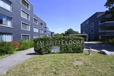 Apartment building, multiple floors, modern architecture, greenery, entrance sign