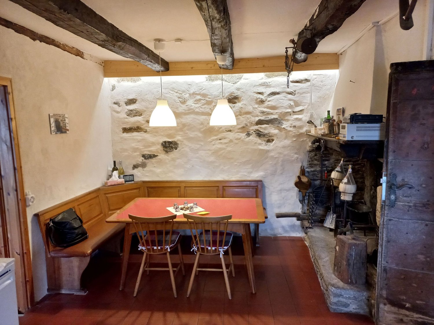 wooden table, chairs, stone walls, fireplace