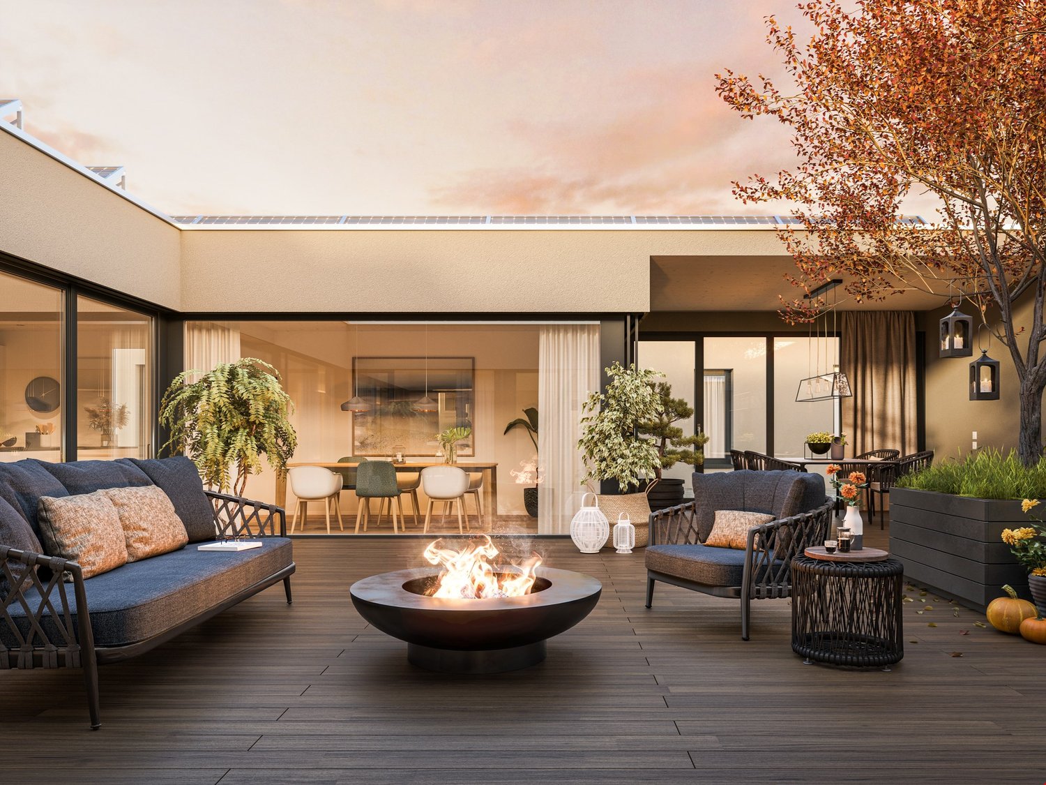 Wooden deck, fire pit, couches, tables, chairs, plants, solar panels on the roof, decorative pumpkins