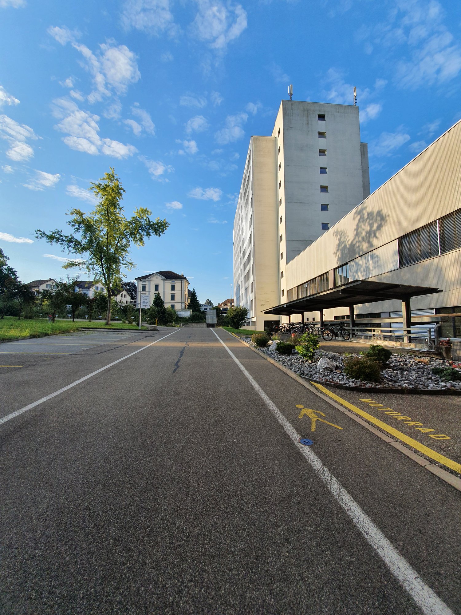 Empty road, building with bicycles parked outside