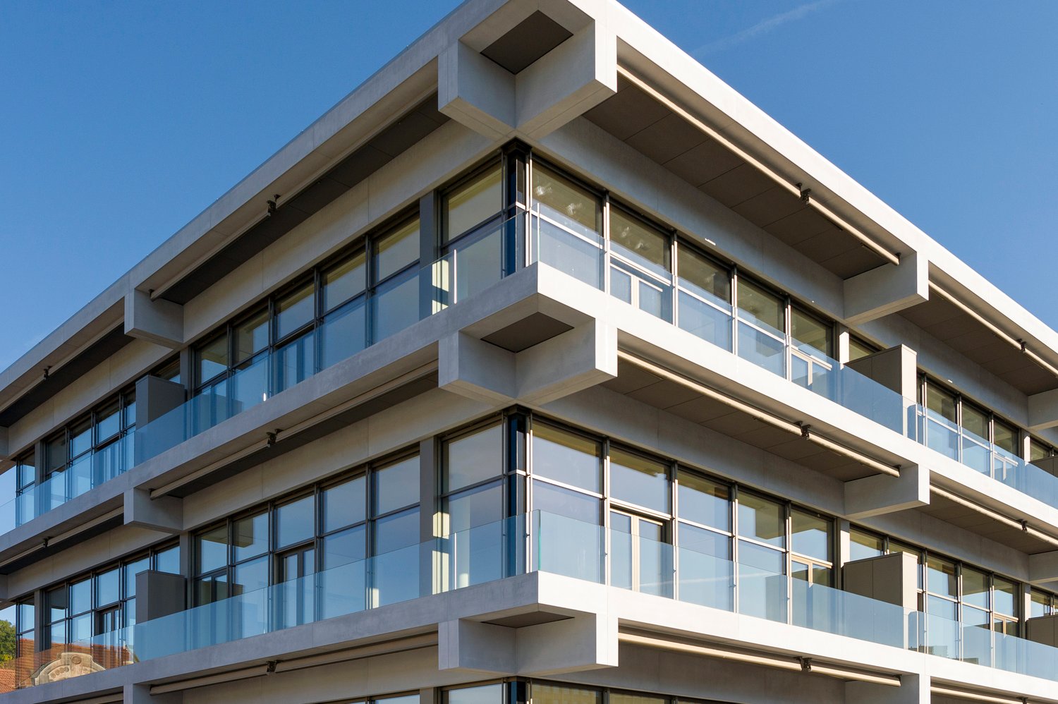 modern design, concrete structure, multiple floors, large glass windows, balconies