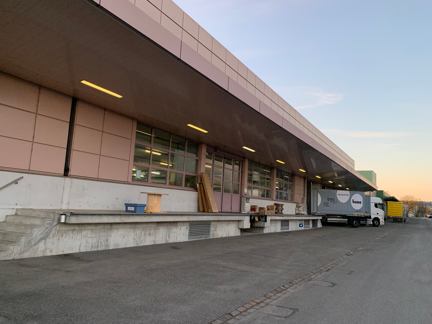 modern industrial building, metal awning, loading dock, truck in front