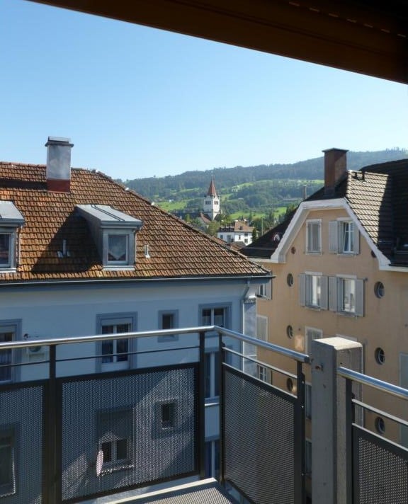 balcony, brown roof, windows, view of town
