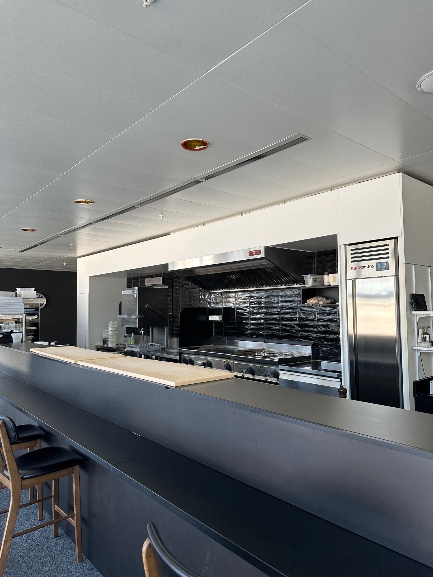 modern commercial kitchen, stainless steel appliances, tiled backsplash, commercial oven, refrigerator