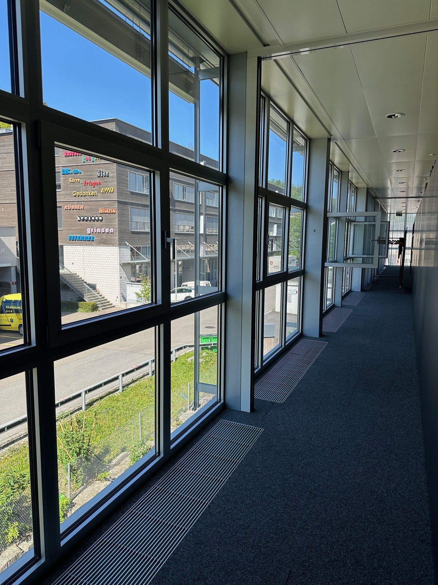 hallway with glass walls, windows with view to the outside