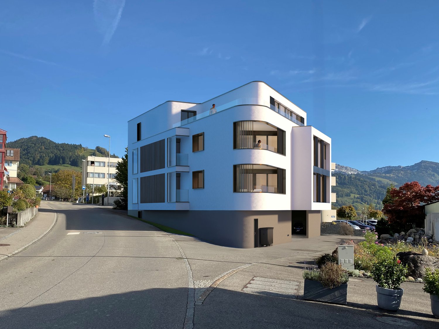 Modern white building, multiple balconies, large windows, parking area, mountains in the background