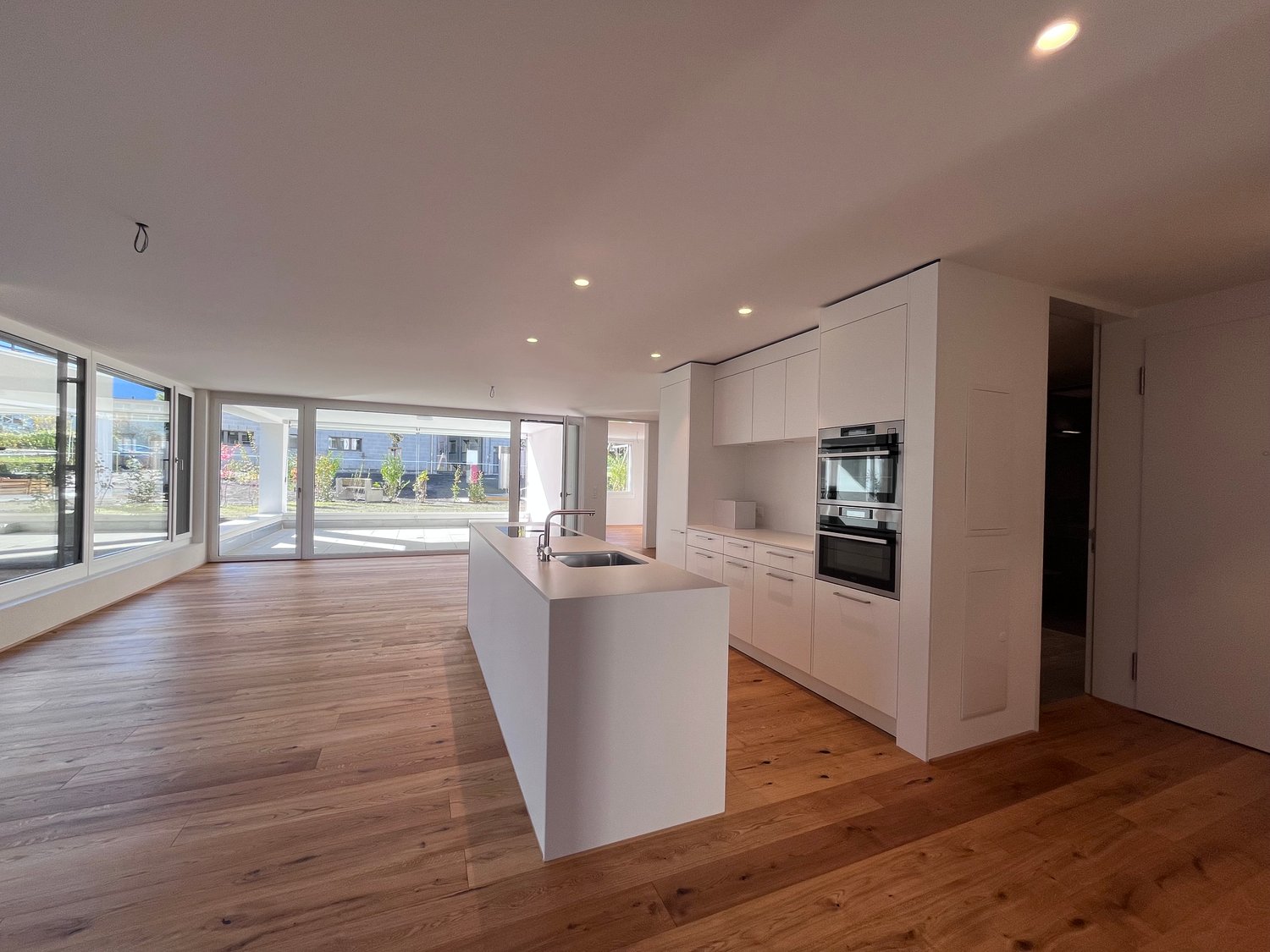 kitchen, island, large windows, modern appliances, wooden floor, open layout