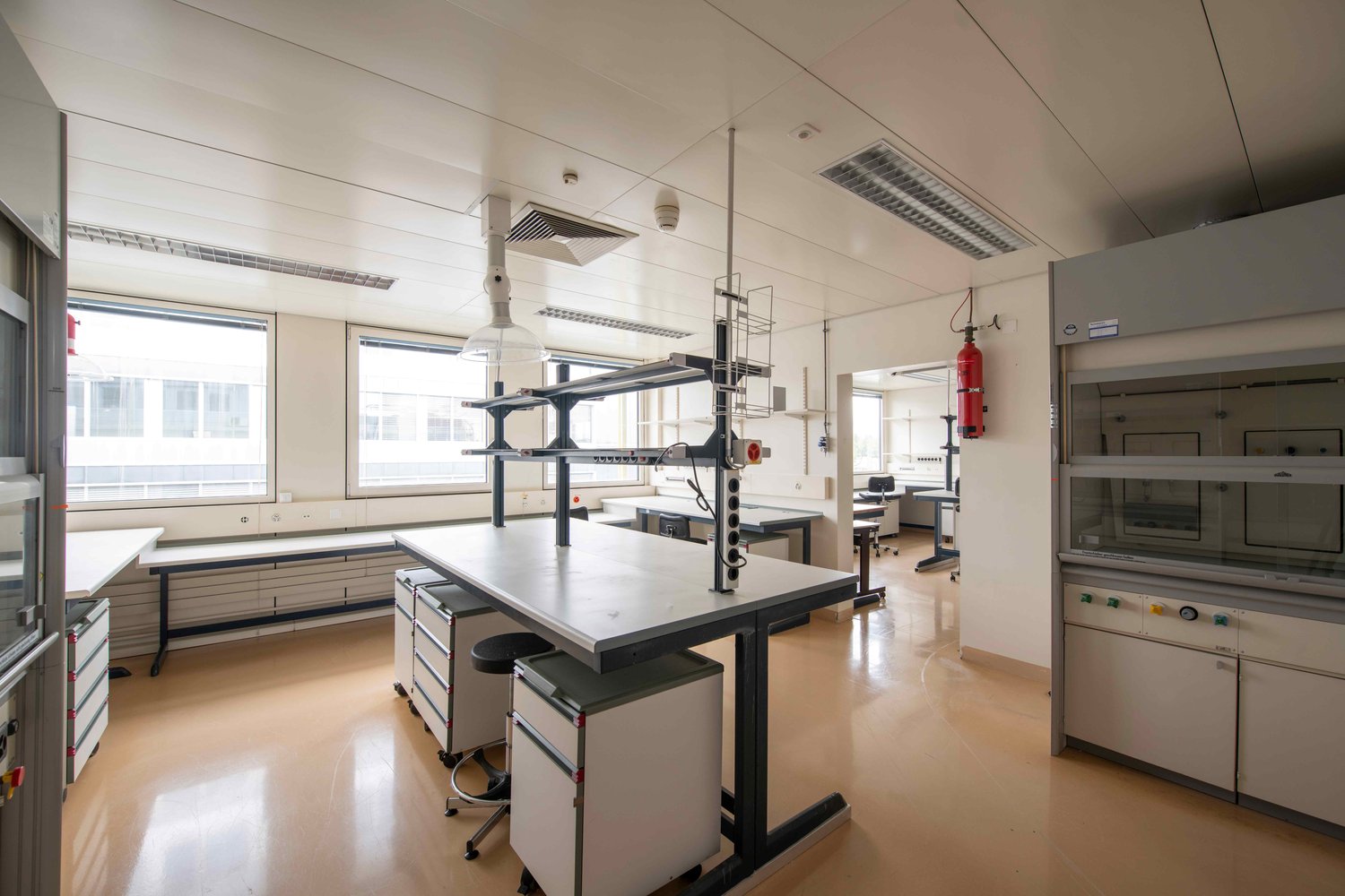 laboratory with tables, chairs, cabinets, fire extinguishers, windows, ventilation systems