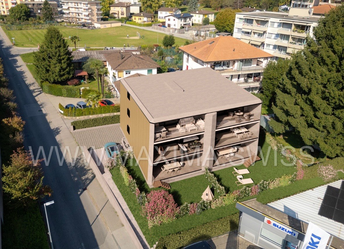 5-storey building, several balconies, multiple cars parked in front, various buildings in the background