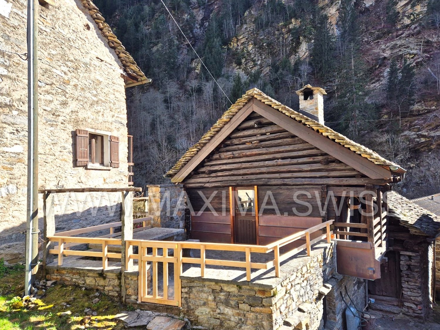 Rustic log cabin house, wooden terrace, stone wall, surrounding mountain