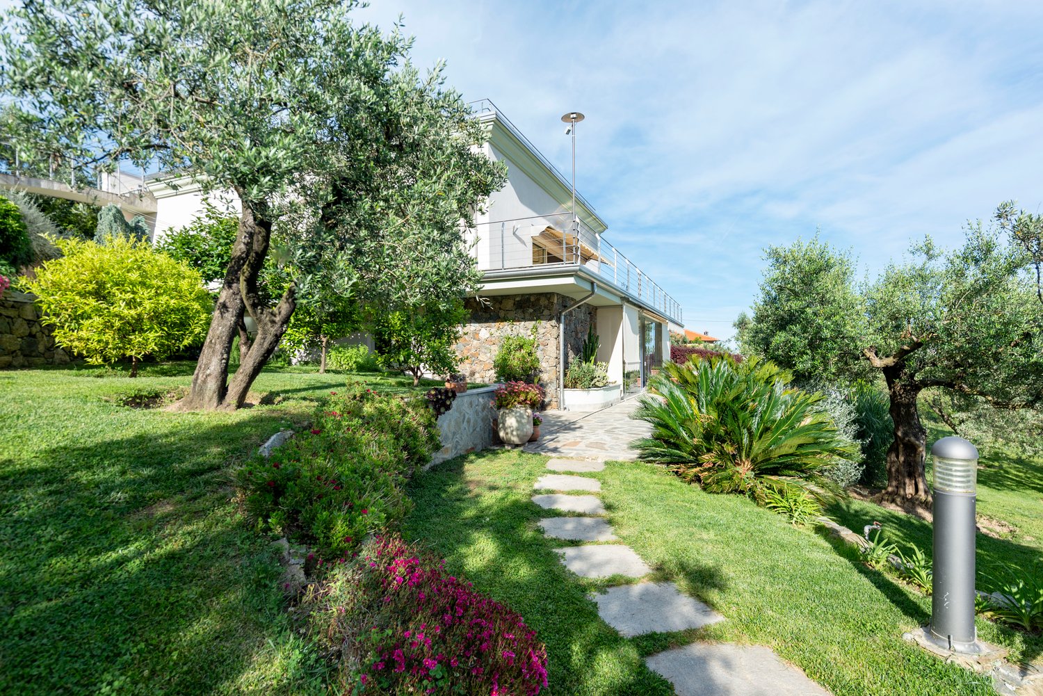 2 story house, white exterior, balcony, garden, olive trees, stone pathway
