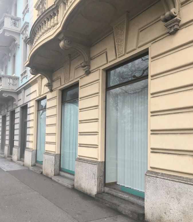 Facade of a building with a balcony, large windows, and decorative elements