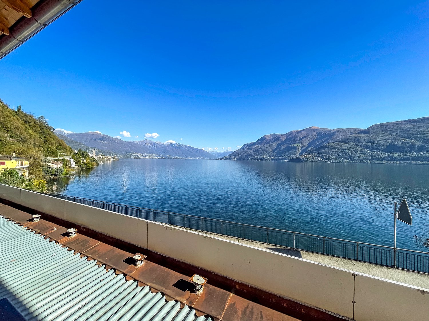 View from the terrace of the lake, mountains, and surrounding buildings.
