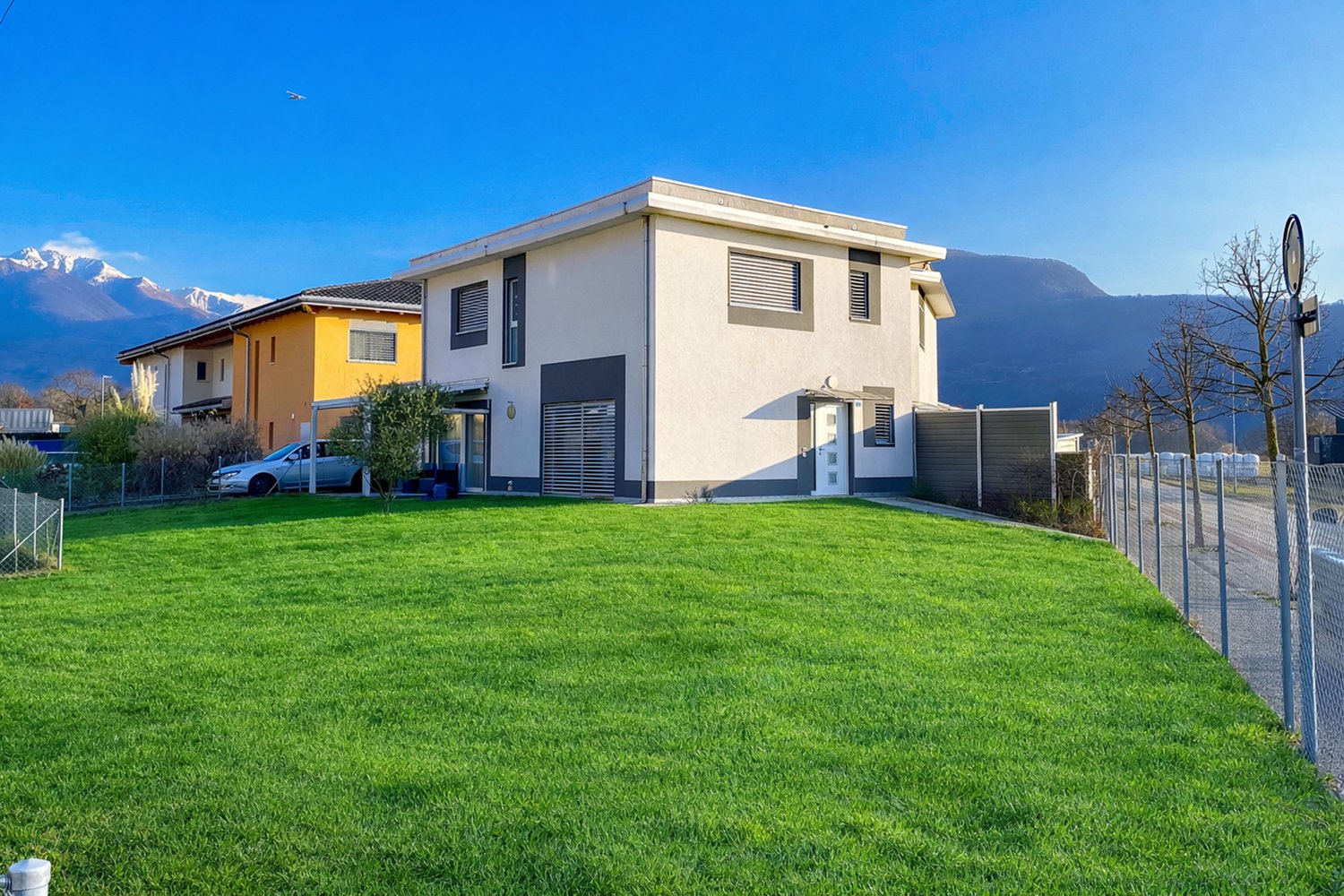 Detached house, white exterior, 2 floors, car parked in front, fenced yard, mountain view