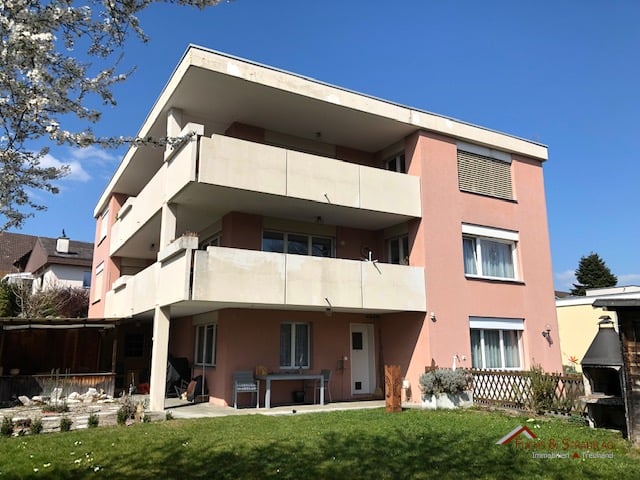 3 story house, pink exterior, balconies, garden, table and chairs