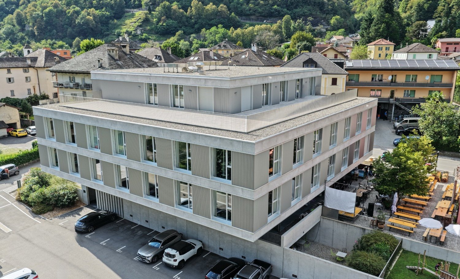 4 story building, concrete exterior, multiple windows, multiple balconies, underground parking, view of town and mountains