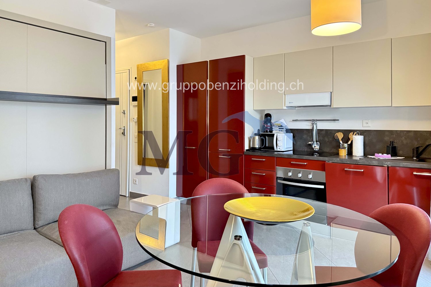 modern kitchen with red cabinets, black countertops, large dining table, modern chairs, glass, microwave, dishwasher, washing machine