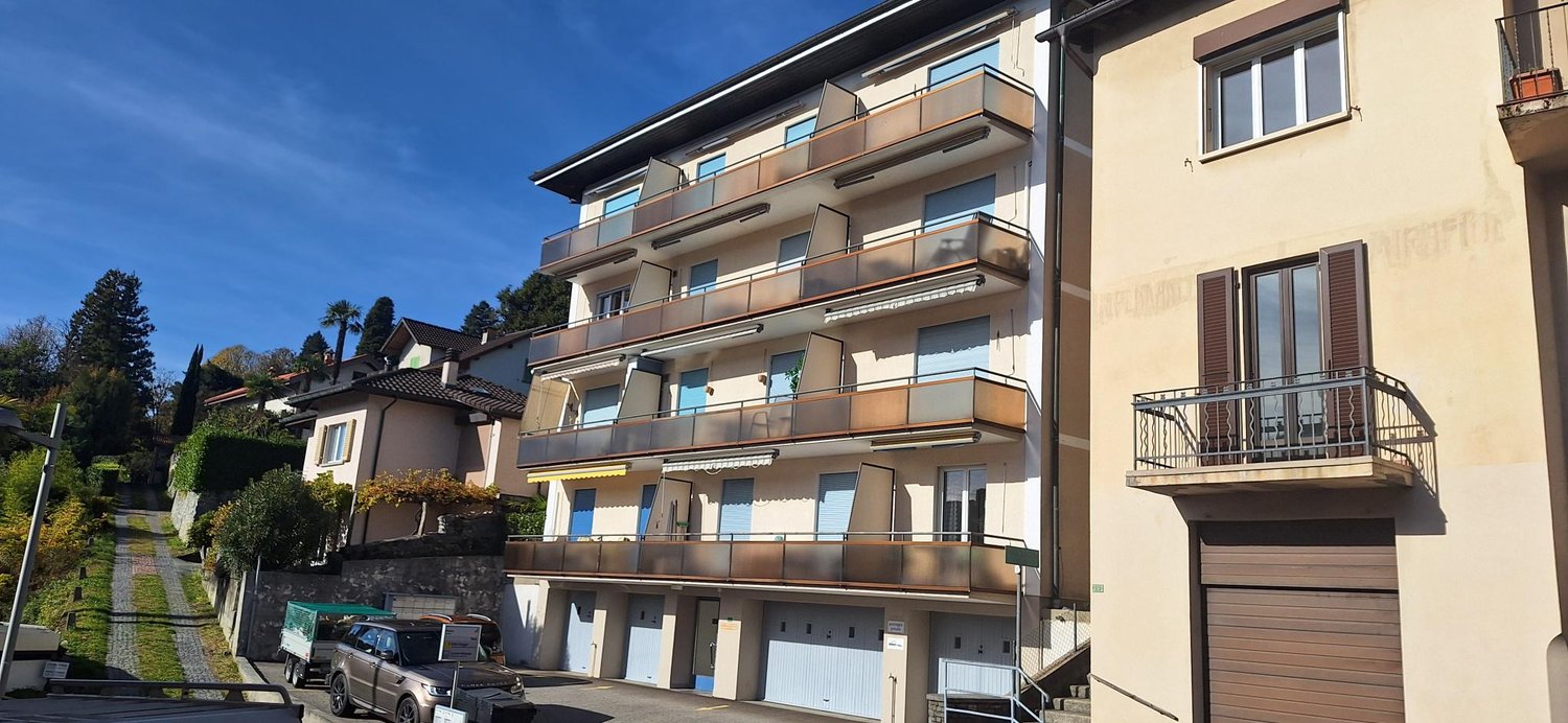 3-story house, beige exterior, multiple balconies, garage entrance, multiple garages