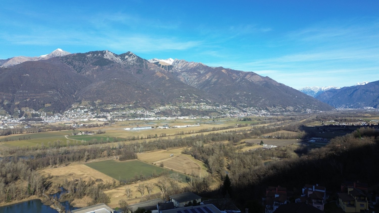 Panoramic view of mountains, houses, and fields.