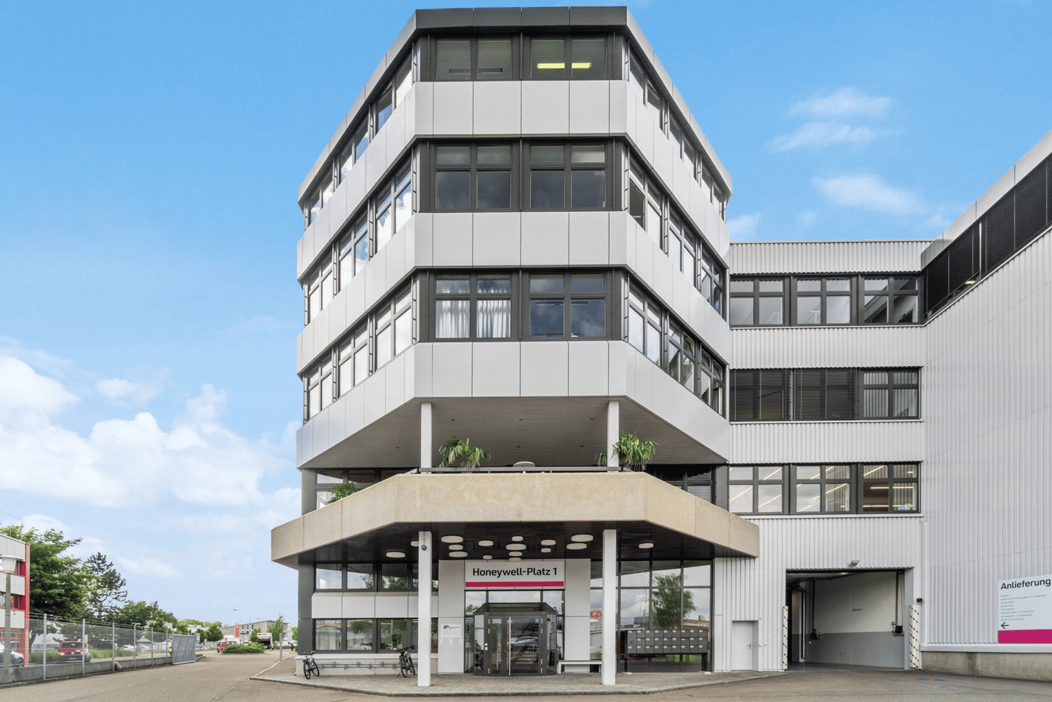modern office building, glass windows, three floors, entrance with glass doors, parked bicycles