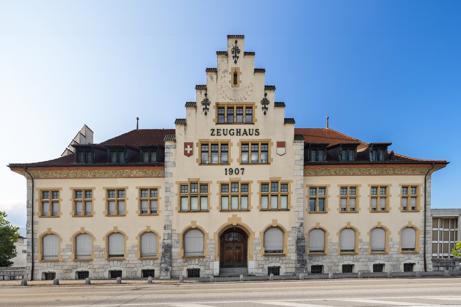 Zeughaus from 1907, large building with multiple windows, wooden doors, and a clock on the tower.