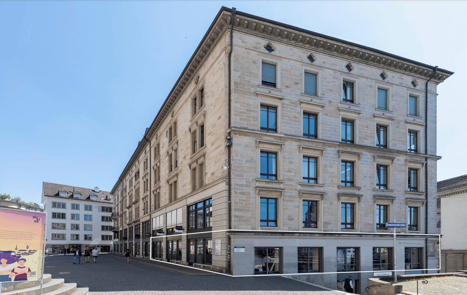 Large office building, stone facade, multiple glass windows, modern architecture, street sign in front, urban setting