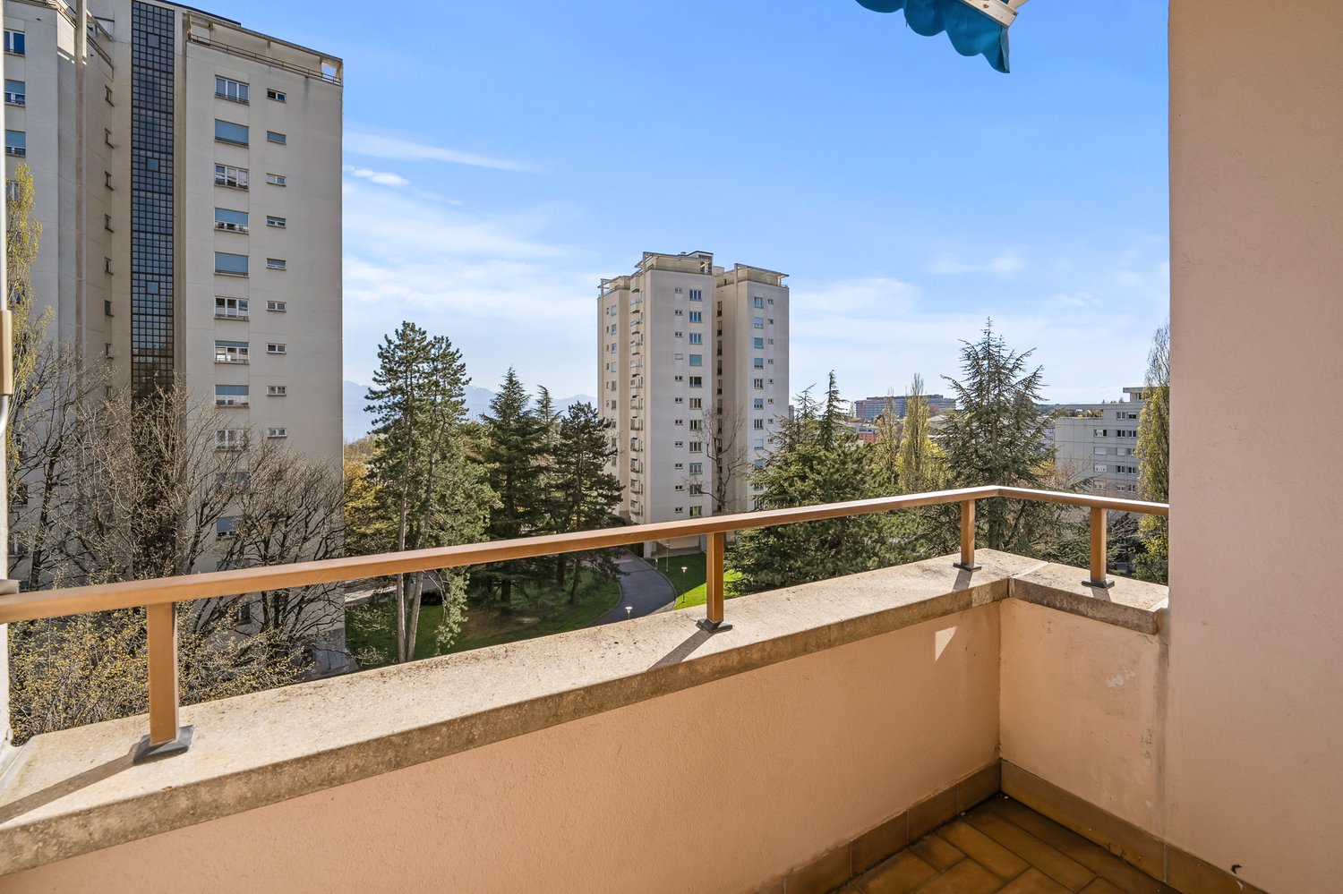 balcony, wooden railing, tiled floor, view of trees and buildings
