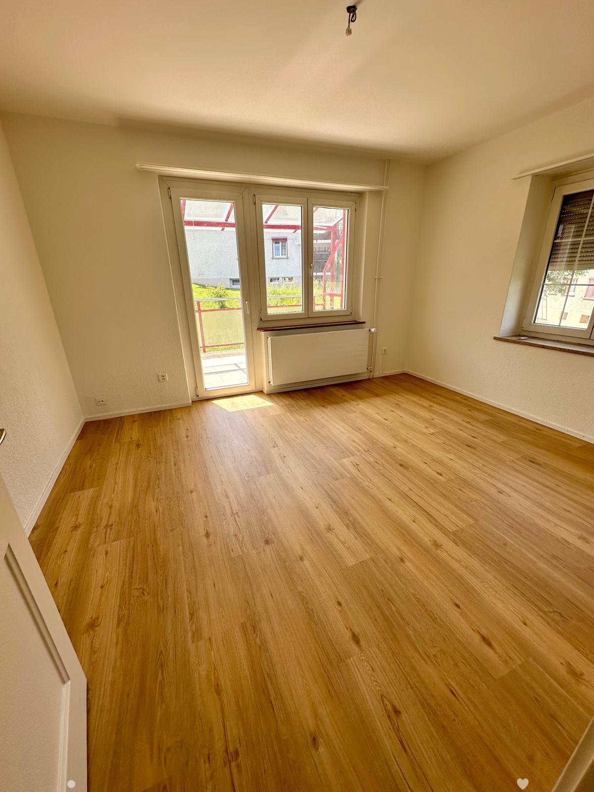 Wooden floor, large window, sliding door to balcony, radiator, two windows