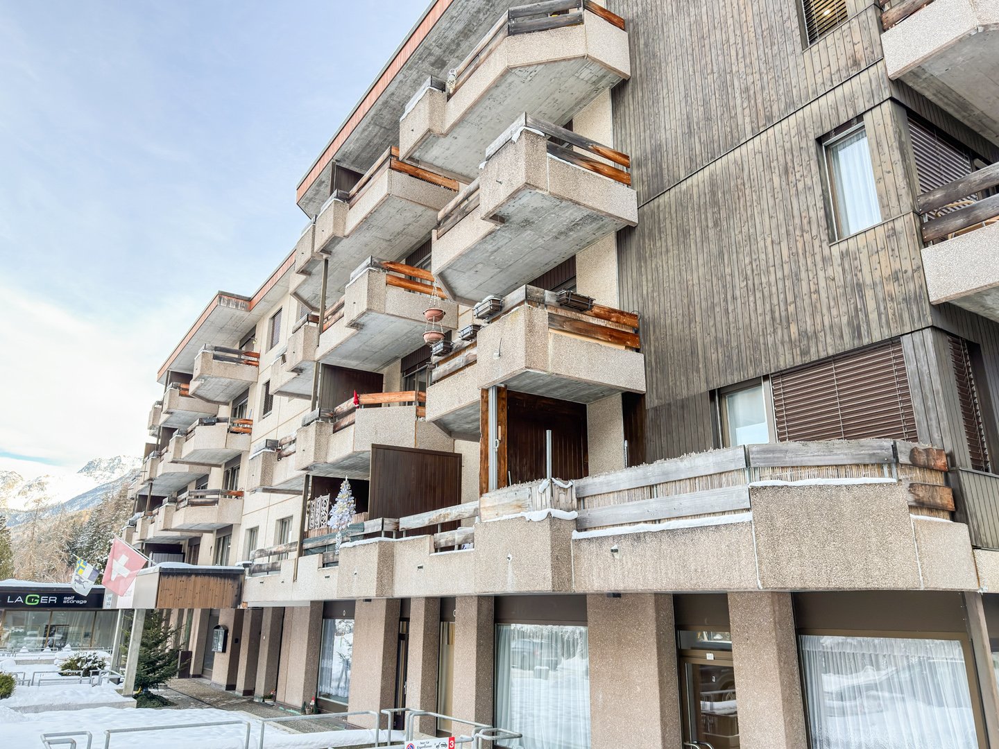 multi-story building, balconies, wood siding, concrete exterior