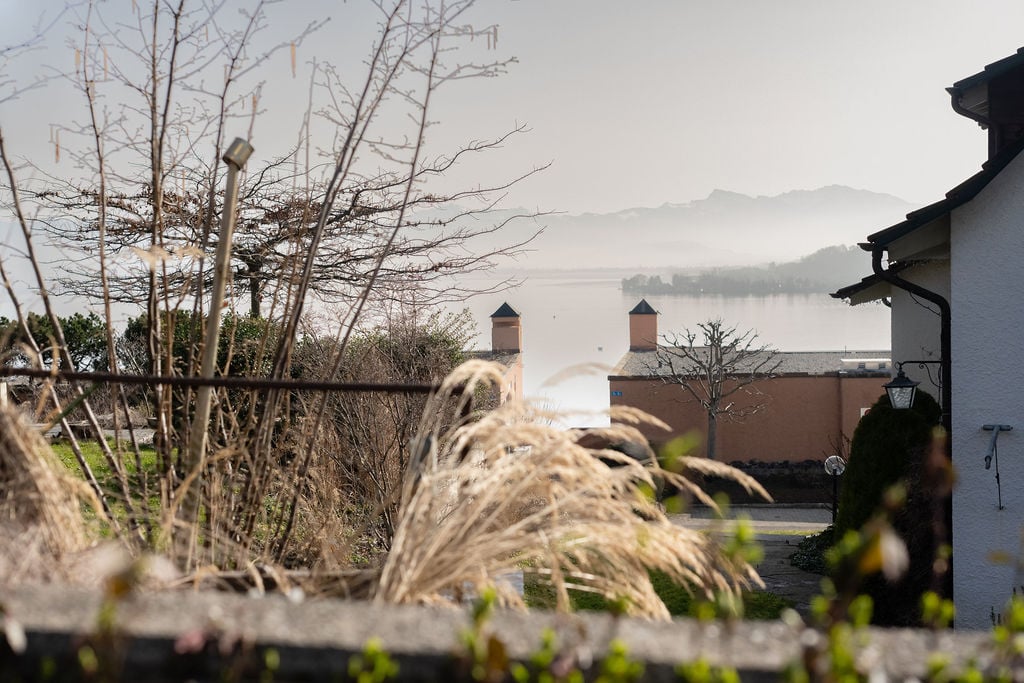 Overlook of a building, with a view of a lake and mountains.
