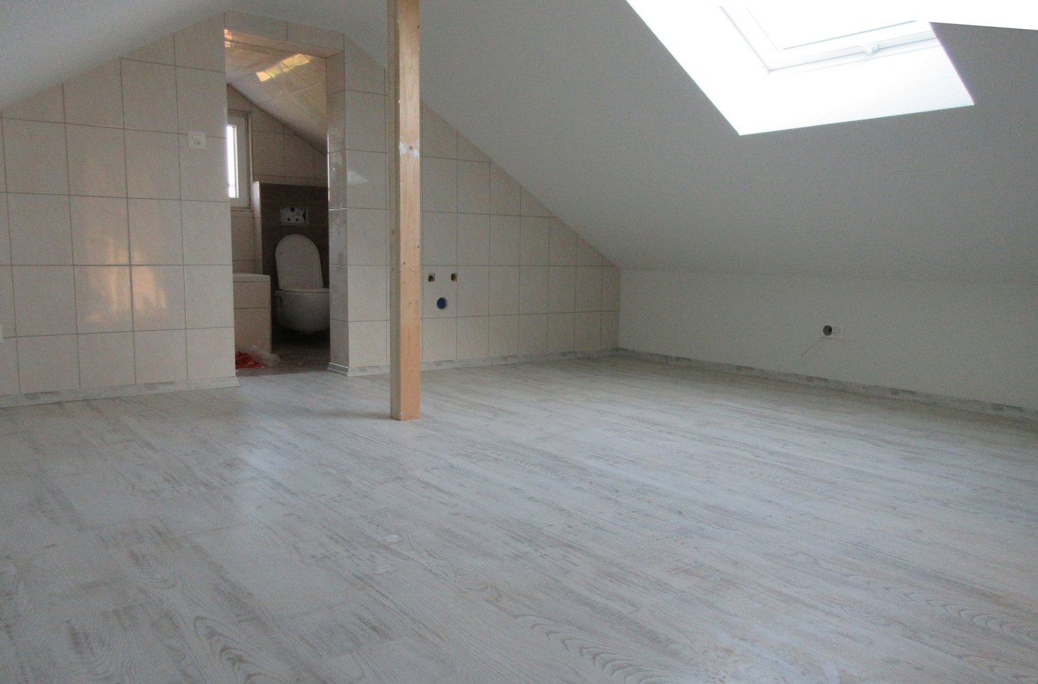 empty room, white tiles, wooden floor, skylight, toilet, small window