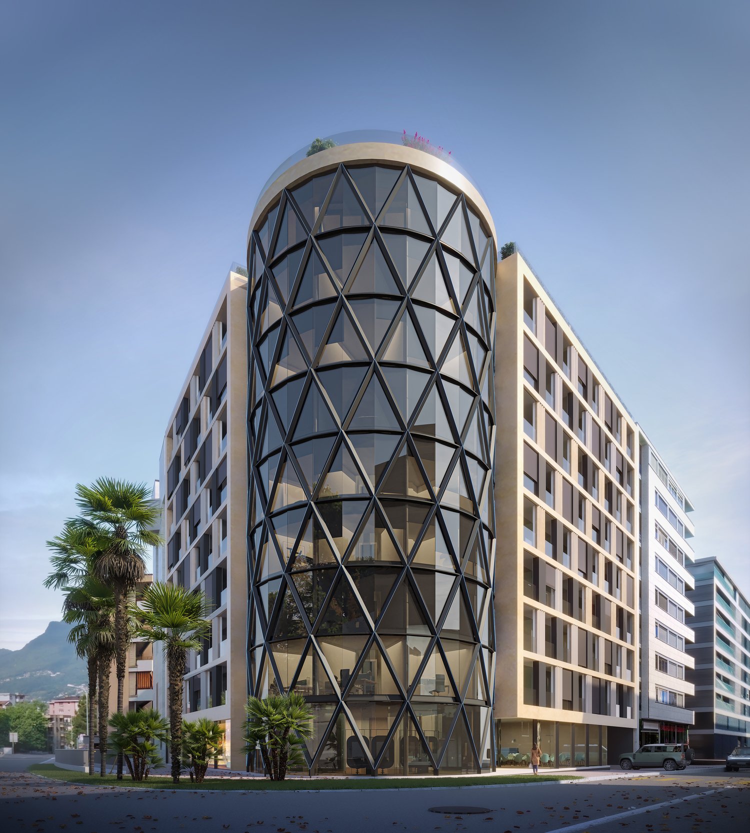 A modern, multi-story building with a distinctive geometric glass facade. The building has a cylindrical tower-like structure at the center, surrounded by rectangular wings. The facade features a pattern of triangular glass panels in various shades of gra