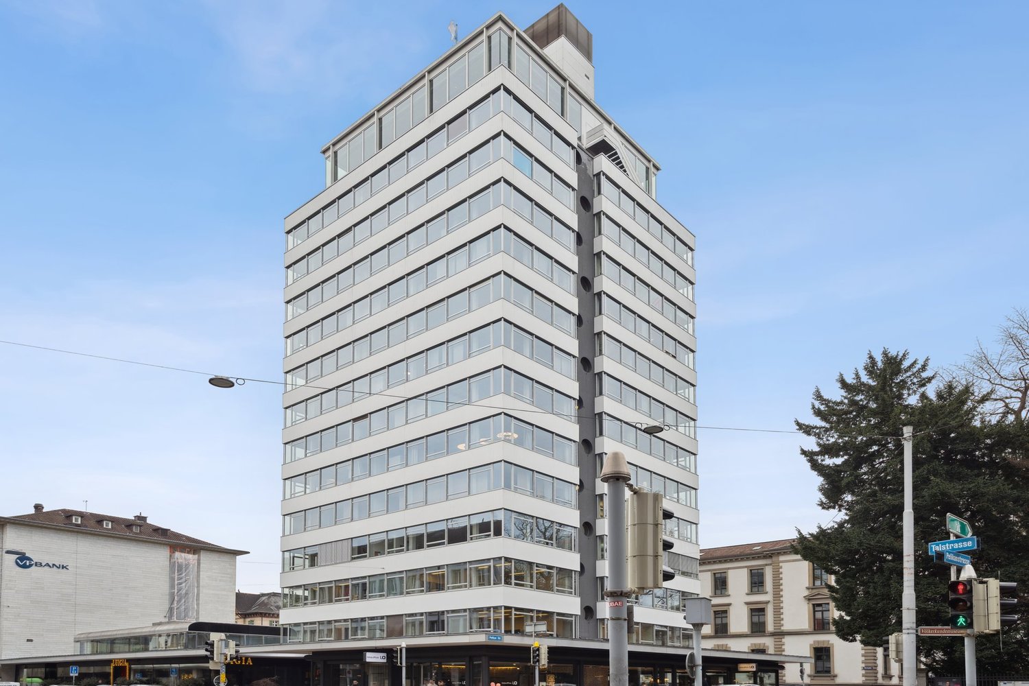 High-rise office building with glass facade, multiple floors, modern architecture, located in an urban area