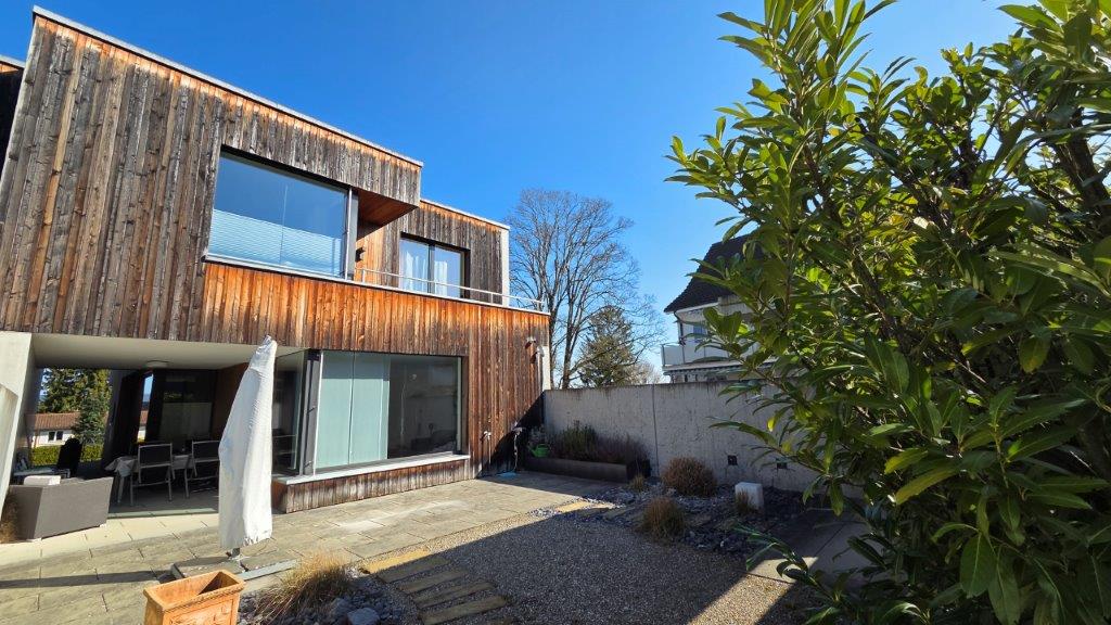 modern wooden house, large windows, balcony, patio, garden
