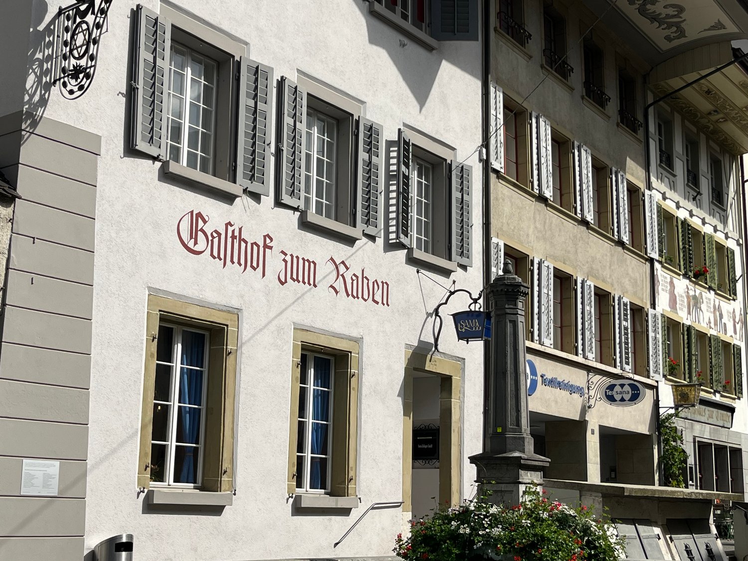 Facade of a building with multiple windows, a lamp, and a sign reading 'Balthof zum Raben'.