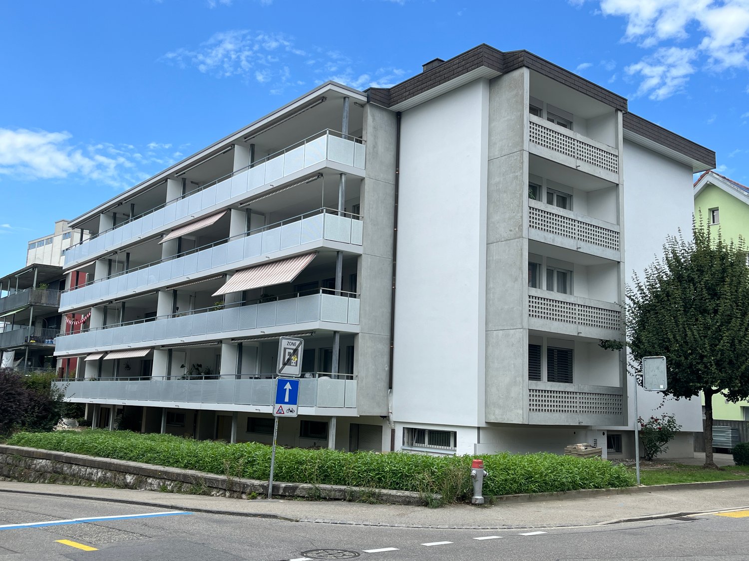 Multi-story apartment building, balconies, concrete exterior, modern design