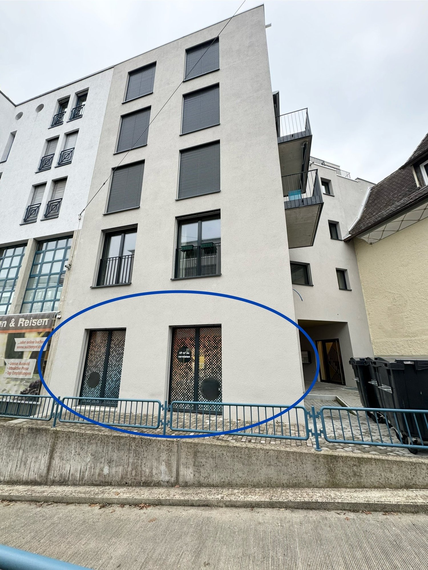 5 story building, white exterior, multiple windows, balconies, entrance highlighted