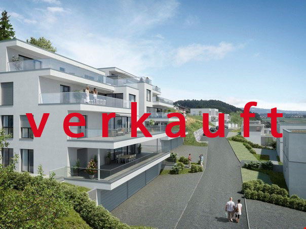 An apartment building made of white material, with many balconies, greenery, and parking area