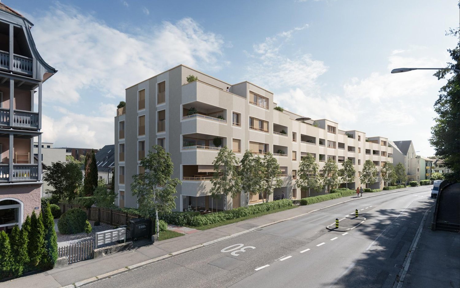 Modern apartment building with multiple balconies and terraces, located on a street with greenery and streetlights