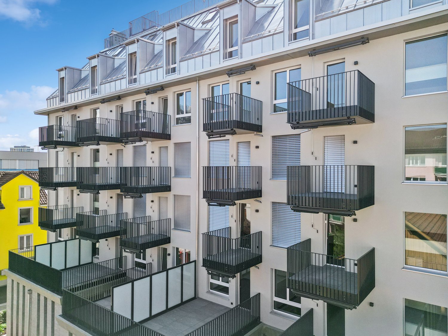 modern multi-story building, balconies, white and grey exterior