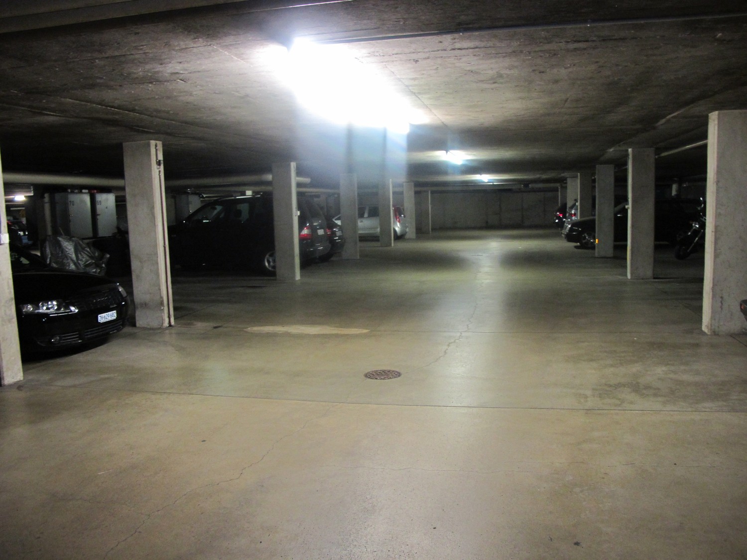 empty multistory underground parking lot with multiple pillars, no visible signs of damage