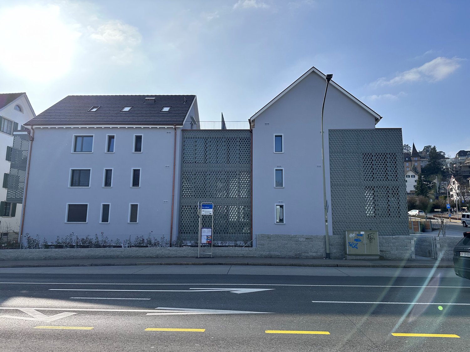 3 story building, white exterior, multiple windows, metal fence, street view