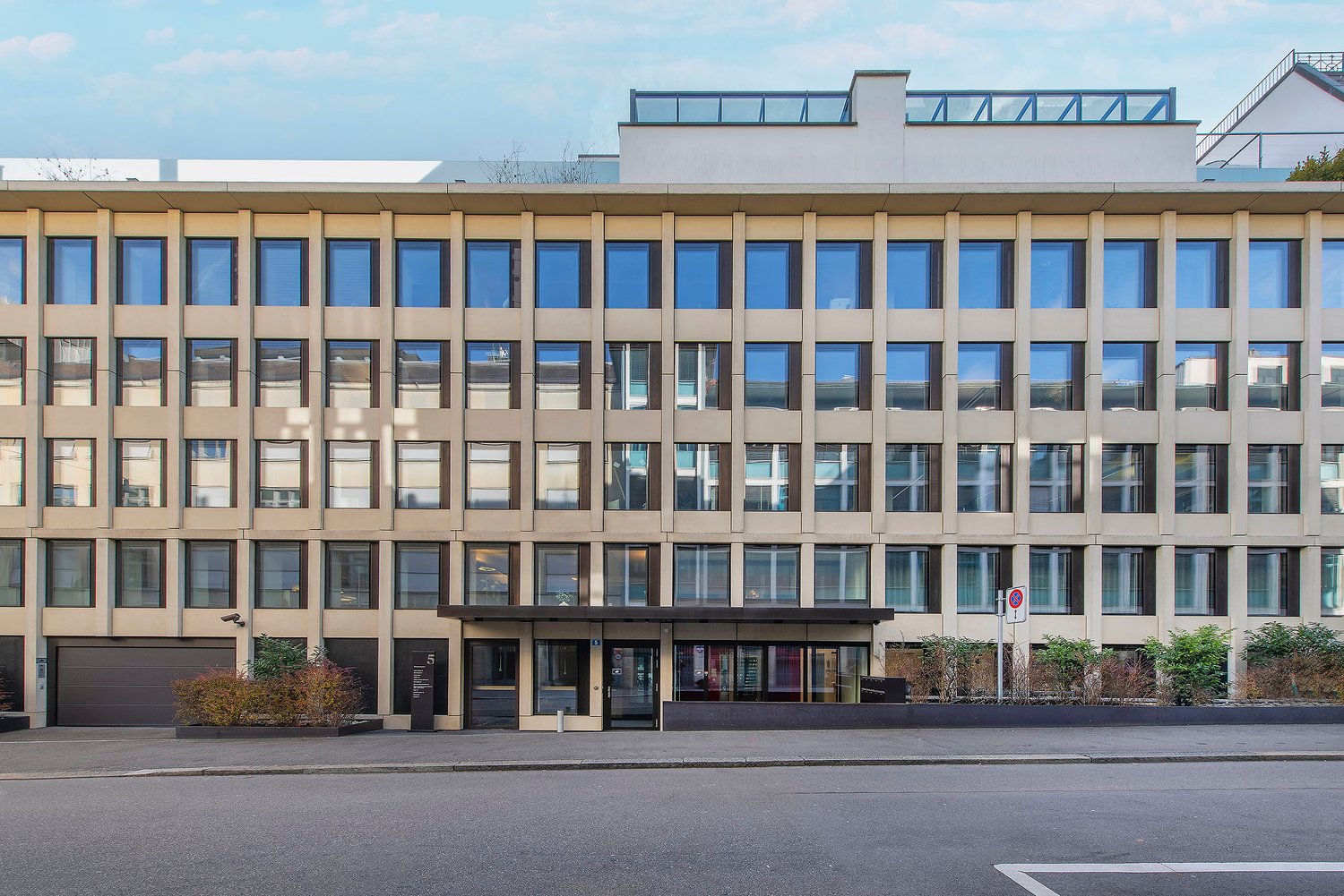 modern office building, multiple windows, large glass entrance, multiple floors, beige color, garage